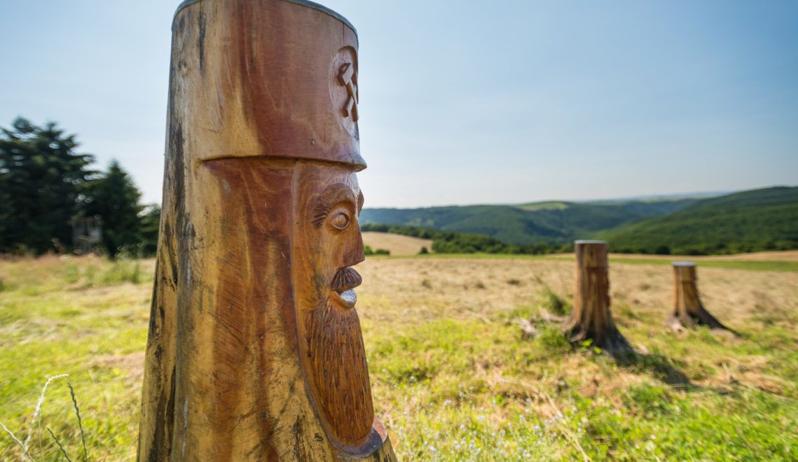Holzfiguren am Wegesrand weisen auf die Geschichte des historischen Zechenwegs hin