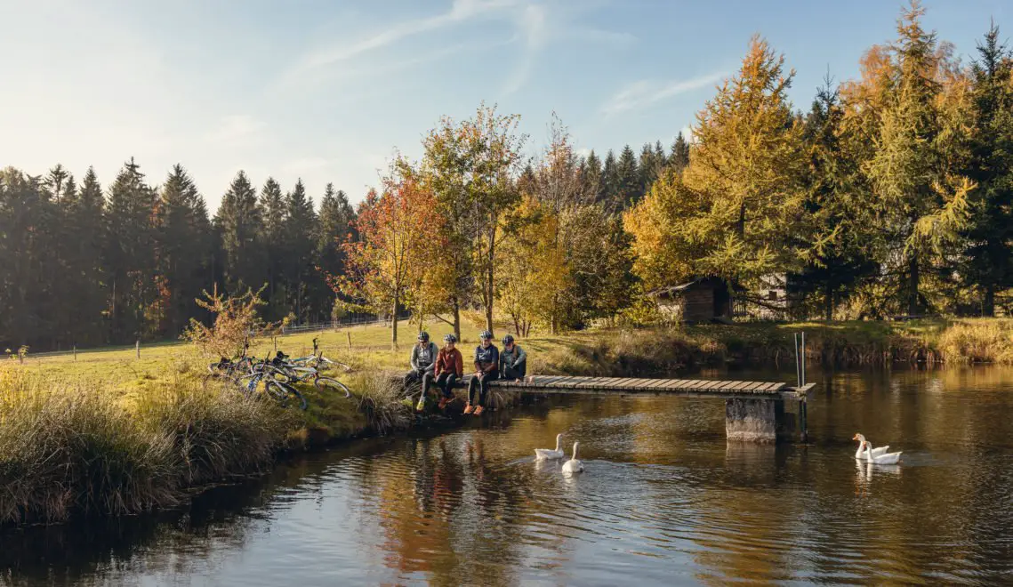 Cyclists sitting on a jetty by the lake