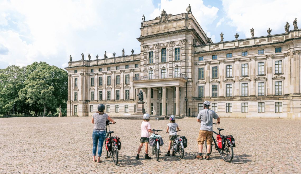 Kompanie stillgestanden: Vor dem Anblick des imposanten Residenzschlosses Ludwigslust staunt auch die munterste Fahrrad-Familie für einen kurzen Moment… ©TMV/Tiemann