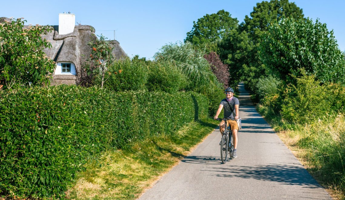 Mit Helm, Charme und kurzer Hose: Radtouren in der Wismarer Bucht sind gesund, idyllisch und fördern interessante modische Ideen ©TMV/Tiemann