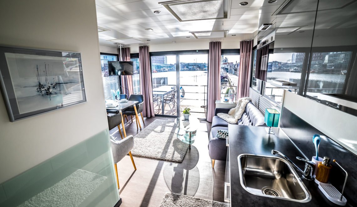 Modern furnishings and a huge window front - a combination that creates the special ambience on the houseboat