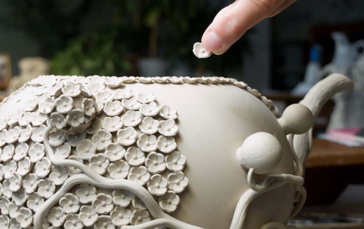 Liebevolle Detailarbeit – eine Teekanne wird mit Schneeballblüten verziert