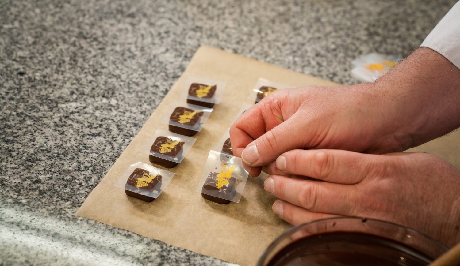Two hands decorate chocolates